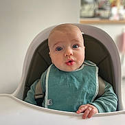 Côme a rejoint le concours — aidez-le/la à gagner de superbes lots ! baby, high_chair, bib, blue_eyes, infant, child, hand, surprised_expression, clothing, indoor, person, seat, young_child, face, head, skin, furniture, babywearing, cute, portrait