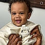 baby, child, smiling, curly_hair, hands, sweater, penguin_design, cozy, portrait, indoor, cute, happy, infant, skin, person, clothing, apparel, face, holding, closeup
