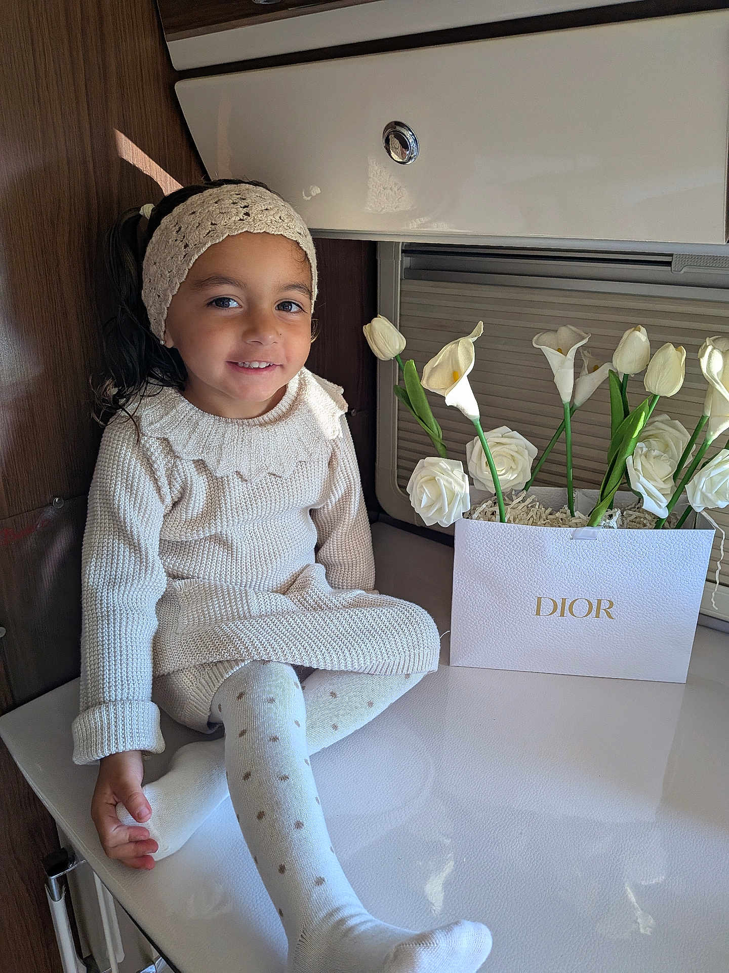 Seyana participe au concours pour gagner de l'argent avec cette photo : child, girl, smile, knitwear, headband, tights, polka_dot, flowers, dior, flower_arrangement, indoor, table, happy, cute, portrait, sitting, cozy, warm_lighting, decor, young