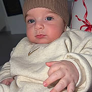 Mathias participe au concours pour gagner de l'argent avec cette photo : baby, infant, child, knit_hat, pom_pom, beige_clothing, indoor, portrait, hand, face, blue_eyes, cute, cozy, young_child, sitting, soft_lighting, close_up, expression, warm_clothing, person