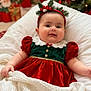 baby, blanket, christmas, chubby_cheeks, cozy, cute, dress, face, festive, green, headband, holiday, holiday_decor, indoor, infant, person, red, smile, soft, warm