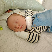 Haroun a rejoint le concours — aidez-le/la à gagner de superbes lots ! baby, newborn, sleeping, striped_clothing, mittens, overalls, crib, pillow, blanket, soft, infant, peaceful, resting, cute, face, head, child, person, sleep, comfortable
