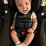 baby, child, car_seat, pink_bow, headband, denim_overalls, white_socks, smiling, happy, infant, safety_harness, seatbelt, cute, portrait, indoor, young_child, baby_clothes, hands, legs, face