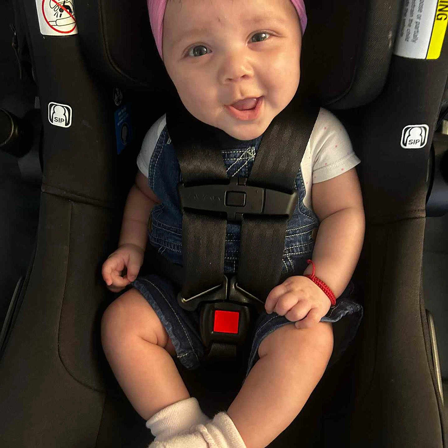 Evelynne joined the competition — help win amazing prizes! baby, baby_clothes, car_seat, child, cute, denim_overalls, face, hands, happy, headband, indoor, infant, legs, pink_bow, portrait, safety_harness, seatbelt, smiling, white_socks, young_child