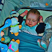 Eyden participe au concours pour gagner de l'argent avec cette photo : baby, sleeping, blanket, crib, stuffed_animals, toy, blue, face, child, cozy, indoor, bed, soft_toys, toddler, comfort, cute, nap, peaceful, infant, bedtime