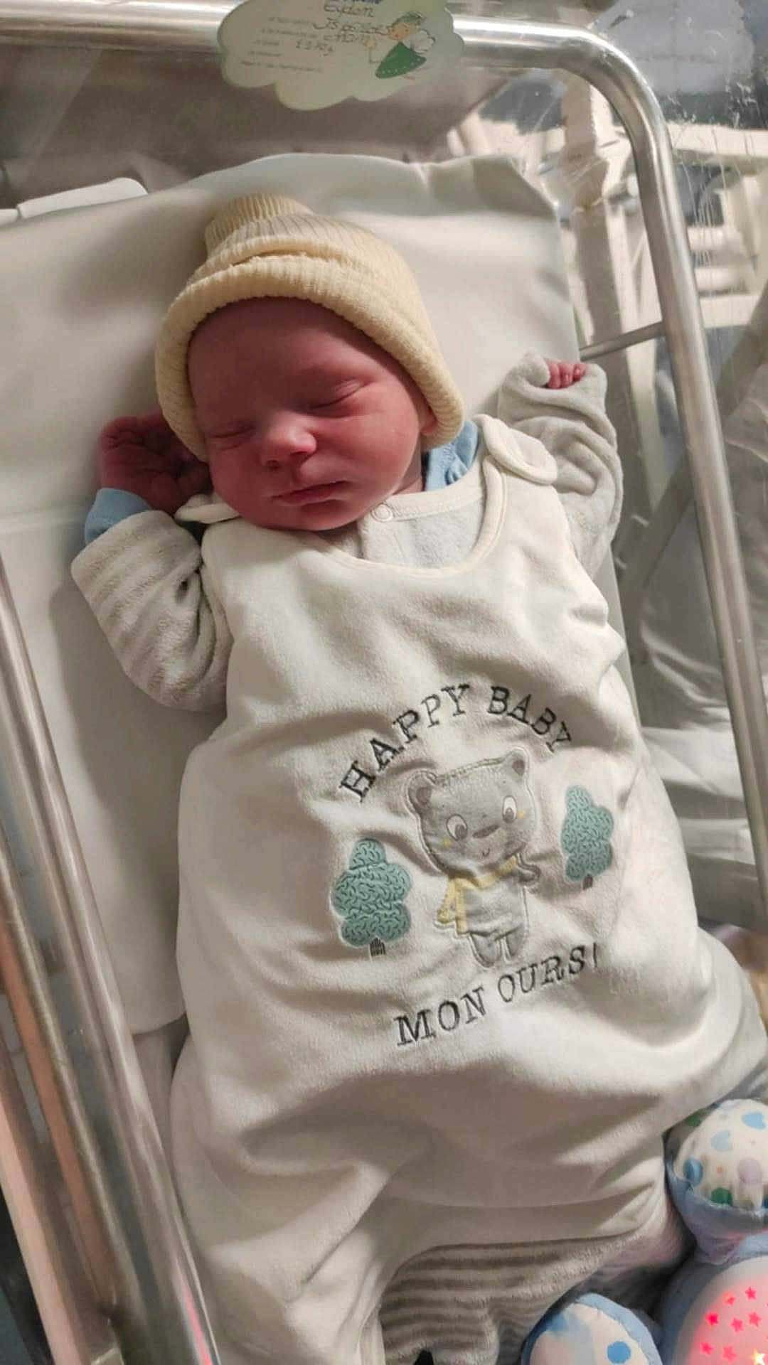 Eyden a rejoint le concours — aidez-le/la à gagner de superbes lots ! newborn, baby, sleeping, hat, hospital, bassinet, clothing, blanket, infant, cute, cozy, peaceful, resting, soft_lighting, indoor, portrait, child, wearing, cute_outfit, baby_sleepwear