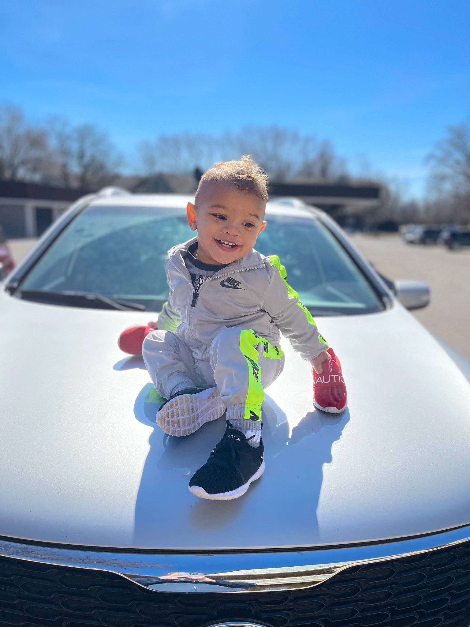 Irie is registered to the contest to win money with this photo: automotive_design, automotive_exterior, automotive_lighting, automotive_wheel_system, bumper, car, grille, headlamp, hood, joy, land_vehicle, motor_vehicle, person, personal_luxury_car, rim, sky, tints_and_shades, toddler, tree, vehicle