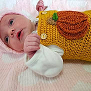 Maeve joined the competition — help win amazing prizes! baby, infant, pink_blanket, knitted_hat, crocheted_outfit, pumpkin_patch, soft_texture, lying_down, cute, small_fist, wide_eyes, white_sleeves, close_up, adorable, newborn, warm_clothing, indoors, portrait, face, child