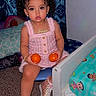 toddler, child, girl, curly_hair, pink_bows, pink_dress, sneakers, oranges, chair, bed, bedroom, carpet, curtains, jewelry, necklace, bracelet, indoor, cute, portrait, playful