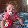 baby, pacifier, plush_toy, bedroom, quilt, blue_eyes, tousled_hair, infant, child, crawling, colorful, soft_light, toy, bed, furniture, curious, indoor, person, cute, casual