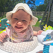 Serena joined the competition — help win amazing prizes! baby, child, smiling, sunhat, outdoor, toy, playtime, cushion, polka_dot, shirt, princess, face, happy, sunny, backyard, grass, tree, fence, ladder, person