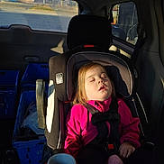 Faith joined the competition — help win amazing prizes! child, toddler, car_seat, sleeping, pink_jacket, seatbelt, plush_toy, car_interior, sunlight, window, blue_crates, cup_holder, seat, resting, young_child, casual_clothing, indoors, daylight, peaceful, relaxed