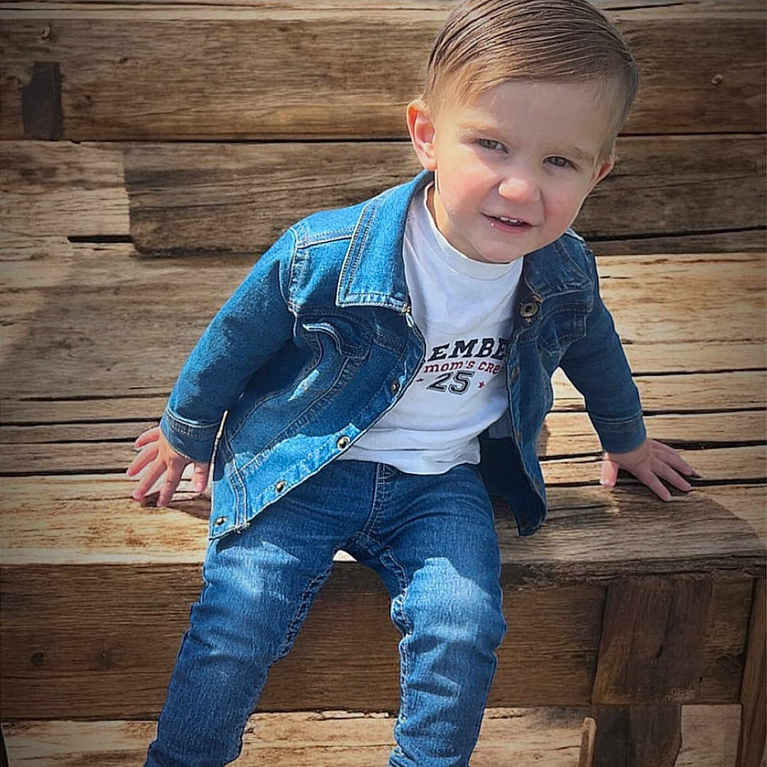 Maylon a rejoint le concours — aidez-le/la à gagner de superbes lots ! black_sneakers, casual_clothing, child, cute, daylight, denim_jacket, face, fashion, hair, happy, jeans, outdoor, person, portrait, sitting, smiling, toddler, water, wood, wooden_bench
