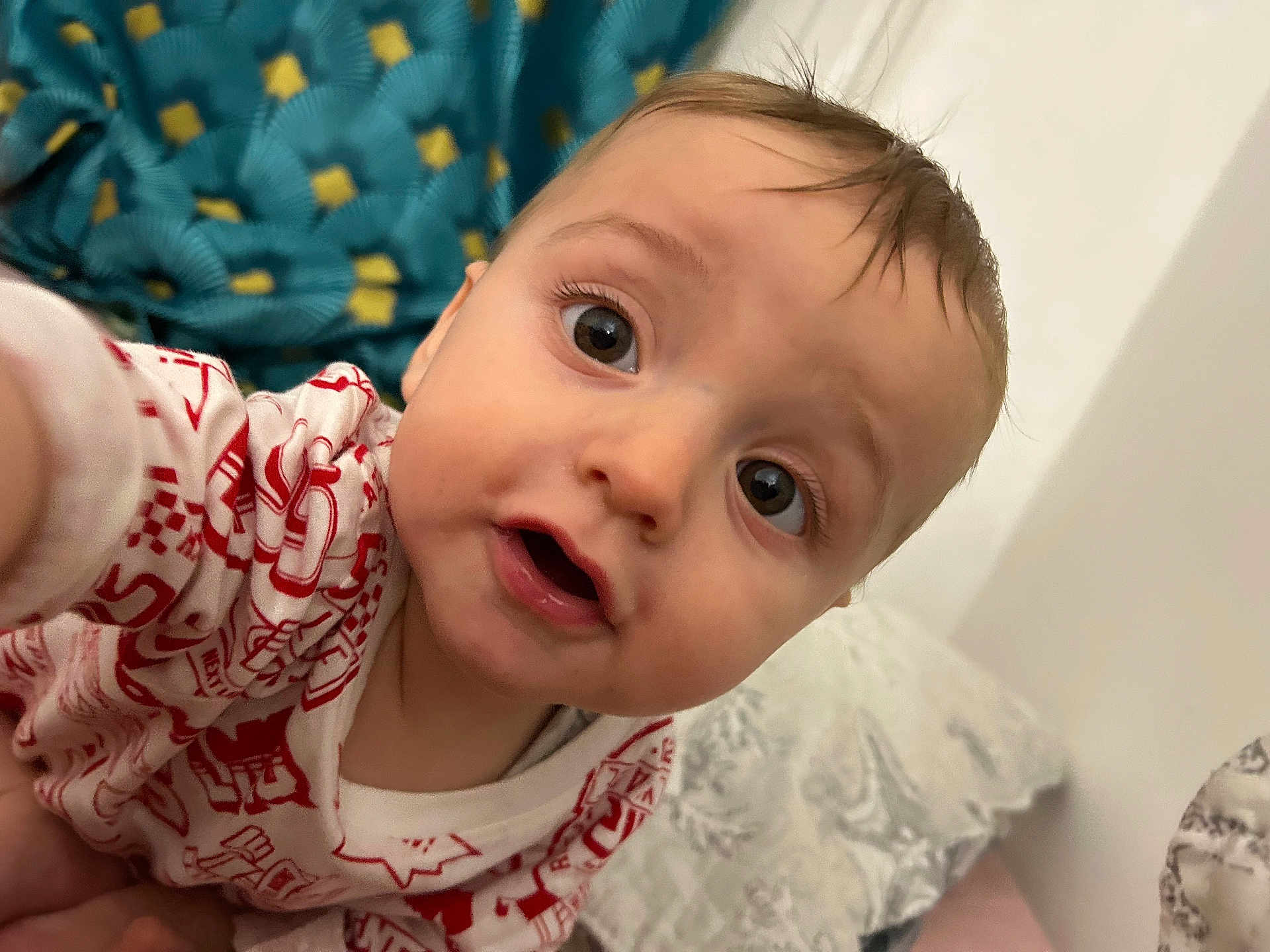Smail a rejoint le concours — aidez-le/la à gagner de superbes lots ! baby, infant, child, face, eyes, mouth, expression, curious, clothing, pattern, pillow, blanket, bed, indoor, person, closeup, skin, hair, head, cute
