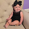 baby, child, black_bow, smile, sitting, beige_chair, upholstery, purple_wall, cute, infant, happy, clothing, indoor, portrait, headwear, armchair, furniture, skin, person, young