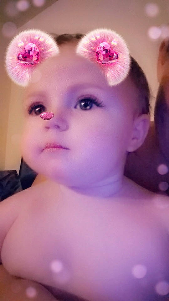 Savanna is registered to the contest to win money with this photo: baby, cheek, child, ear, eye, eyebrow, eyelash, face, hair_accessory, head, iris, lilac, lip, nose, person, photography, pink, purple, skin, toddler