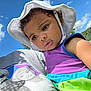 Ziyah joined the competition — help win amazing prizes! baby, bonnet, cap, clothing, dress, face, grass, hat, head, nature, outdoors, person, photography, plant, portrait, purple, sky, summer, sunhat, t_shirt