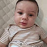Noah is registered to the contest to win money with this photo: apparel, baby, cheeks, child, closeup, cute, eyes, face, head, indoors, infant, lying_down, mouth, newborn, portrait, quilted_background, skin, soft_lighting, striped_clothing, young_child