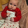 baby, infant, child, red_clothing, heart_pattern, blanket, soft_fabric, sitting, indoors, cute, face, expression, hands, warm, cozy, person, portrait, head, eyes, young