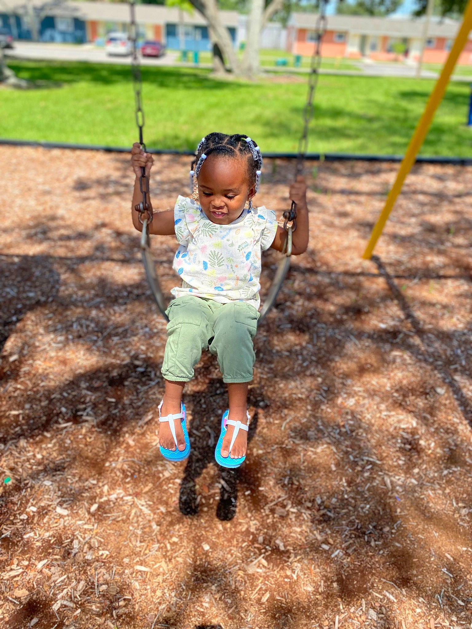 Sariyah is registered to the contest to win money with this photo: baby, baby_toddler_clothing, child, city, fun, grass, happy, joy, leisure, outdoor_play_equipment, people_in_nature, person, plant, play, playground, recreation, shorts, soil, swing, t_shirt