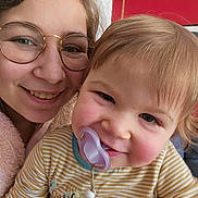 Nao participe au concours pour gagner de l'argent avec cette photo : baby, cheeks, child, closeup, cute, face, family, glasses, hair, happy, indoor, joy, pacifier, person, portrait, smile, striped_clothing, toddler, warm, woman
