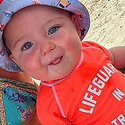 Ghjuvanni participe au concours pour gagner de l'argent avec cette photo : baby, beach, blue_eyes, cheeks, child, clothing, cute, face, happy, hat, infant, lifeguard_shirt, orange_shirt, outdoor, person, sand, skin, smile, summer, sunhat