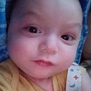 Isaiah is registered to the contest to win money with this photo: baby, infant, close_up, face, eyes, cheeks, lips, onesie, blanket, portrait, skin, gaze, newborn, candid, soft_light, yellow_clothing, swaddle, bed, expression, head