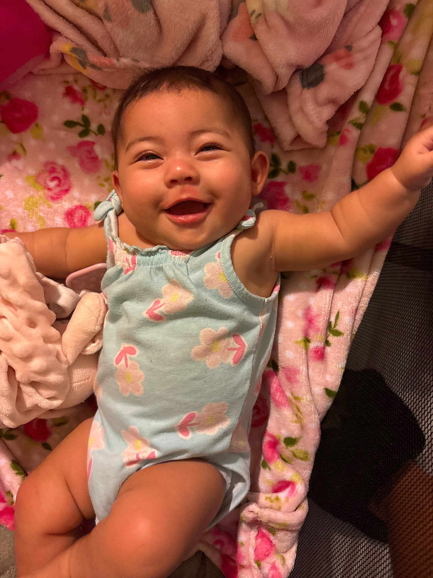 Jayleen joined the competition — help win amazing prizes! baby, smiling, happy, infant, onesie, floral, blanket, patterned, cute, lying_down, skin, arm, face, cheerful, indoors, soft, child, expression, playful, comfort