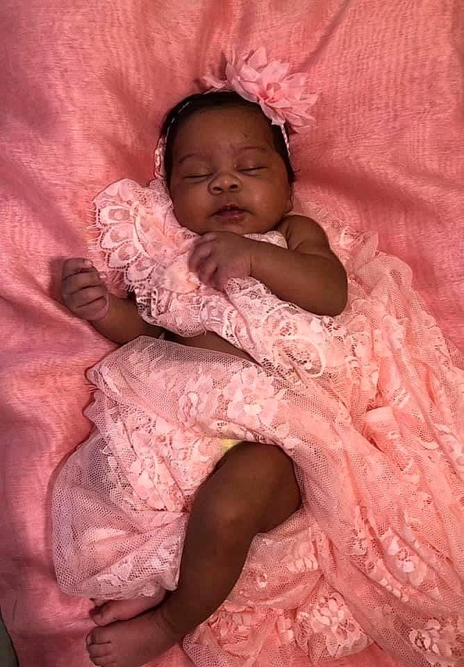 Kemoni is registered to the contest to win money with this photo: baby, baby_toddler_clothing, cheek, child, comfort, embellishment, flesh, foot, hair_accessory, linens, nose, peach, person, pink, skin, toddler