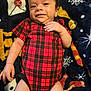 Dreux joined the competition — help win amazing prizes! baby, infant, smiling, red_onesie, plaid_pattern, blanket, patterned_blanket, lying_down, skin, hand, face, cute, child, young, comfort, indoors, closeup, happy, cozy, person