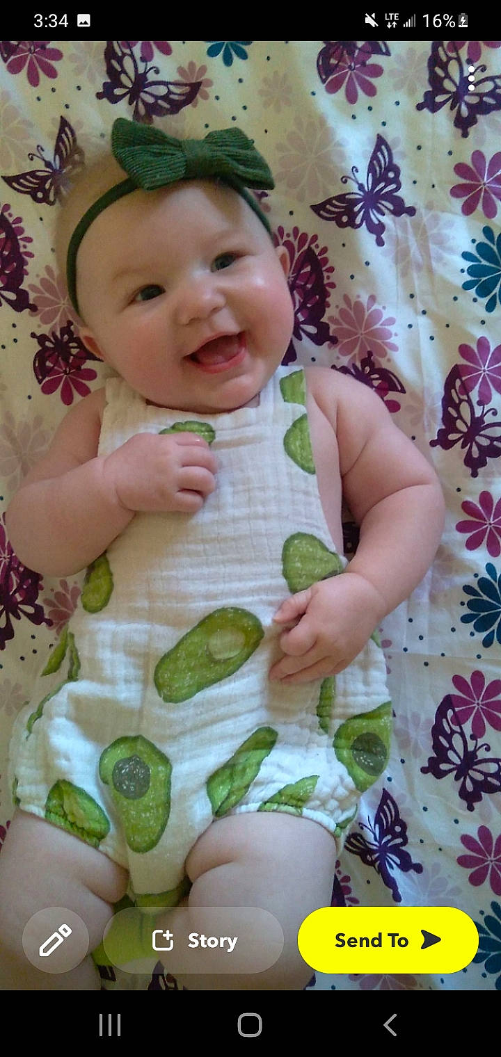 Josie is registered to the contest to win money with this photo: baby, baby_toddler_clothing, cheek, child, dress, face, finger, green, happy, headwear, pattern, person, photograph, pink, product, skin, sleeve, smile, textile, toddler