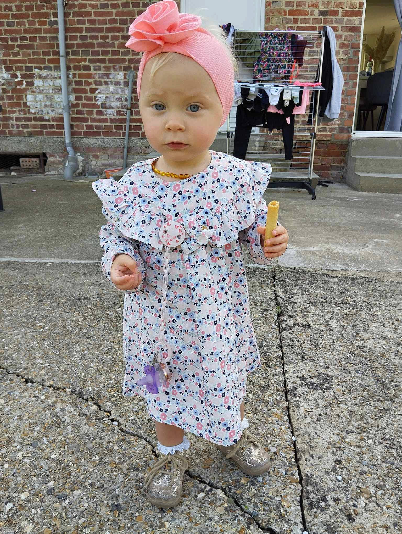 Syhanna participe au concours pour gagner de l'argent avec cette photo : asphalt, baby, baby_toddler_clothing, bench, child, day_dress, dress, eye, fashion_accessory, flooring, hairstyle, human_leg, magenta, pattern, person, pink, road_surface, sidewalk, sleeve, street