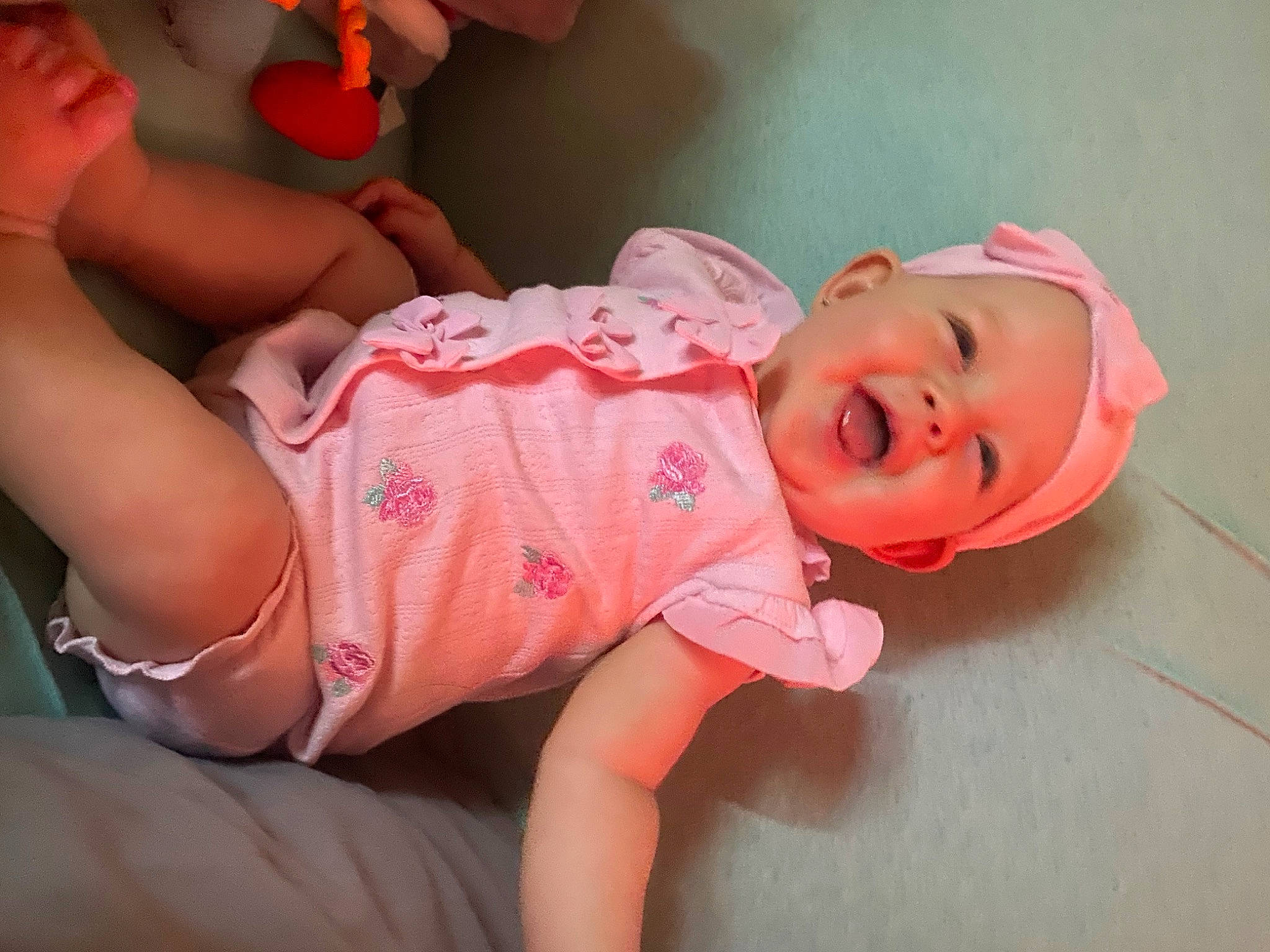 Zoie is registered to the contest to win money with this photo: baby, baby_toddler_clothing, cheek, comfort, finger, happy, headgear, headwear, human_body, joint, leg, lip, mouth, neck, nose, orange, person, pink, skin, sleeve