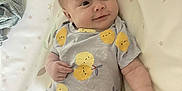 Apolline participe au concours pour gagner de l'argent avec cette photo : baby, blanket, child, clothing, cute, expression, face, hand, head, indoors, infant, lemons, lying_down, onesie, pattern, portrait, skin, smiling, soft, stars