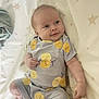 baby, blanket, child, clothing, cute, expression, face, hand, head, indoors, infant, lemons, lying_down, onesie, pattern, portrait, skin, smiling, soft, stars