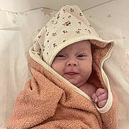 Apolline participe au concours pour gagner de l'argent avec cette photo : baby, blanket, cheeky, child, cozy, cute, expression, face, floral, hand, hood, indoors, infant, lying, newborn, skin, soft, star_pattern, towel, wrapped