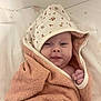 baby, blanket, cheeky, child, cozy, cute, expression, face, floral, hand, hood, indoors, infant, lying, newborn, skin, soft, star_pattern, towel, wrapped