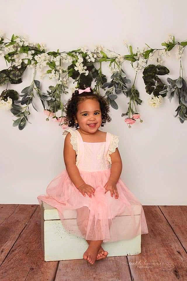 Aylin is registered to the contest to win money with this photo: child, child_model, costume, dress, fashion_accessory, flower, flower_girl, happy, joy, person, petal, photography, pink, plant, shoulder, sitting, smile, toddler, white