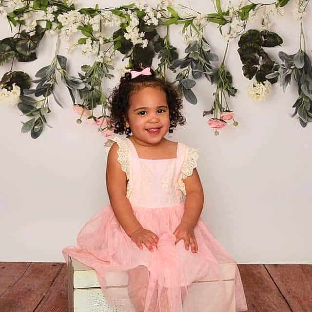 Aylin is registered to the contest to win money with this photo: child, child_model, costume, dress, fashion_accessory, flower, flower_girl, happy, joy, person, petal, photography, pink, plant, shoulder, sitting, smile, toddler, white