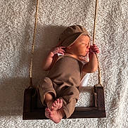 Hudson joined the competition — help win amazing prizes! newborn, baby, sleeping, swing, rope, wood, brown_clothing, hat, blanket, cozy, infant, peaceful, portrait, soft_texture, indoor, cute, resting, small_feet, child, warm_lighting