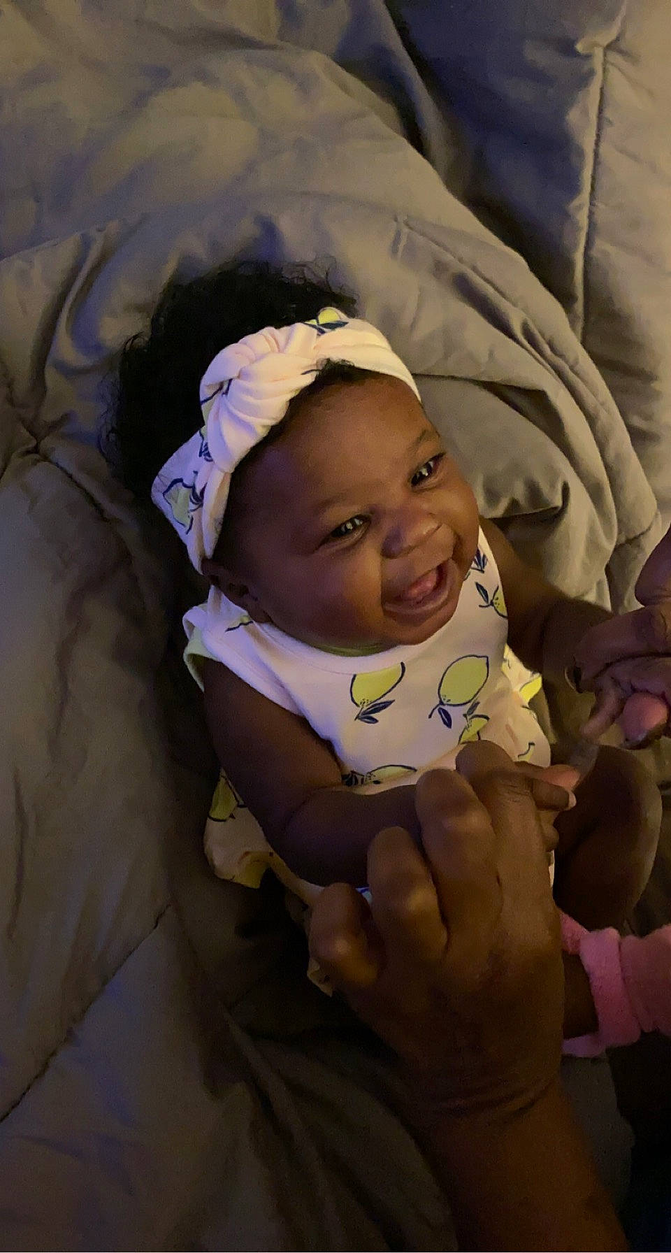 Zi'Yona is registered to the contest to win money with this photo: baby, baby_products, baby_toddler_clothing, cheek, child, comfort, eyebrow, face, fun, gesture, happy, head, iris, linens, mouth, person, purple, room, skin, smile