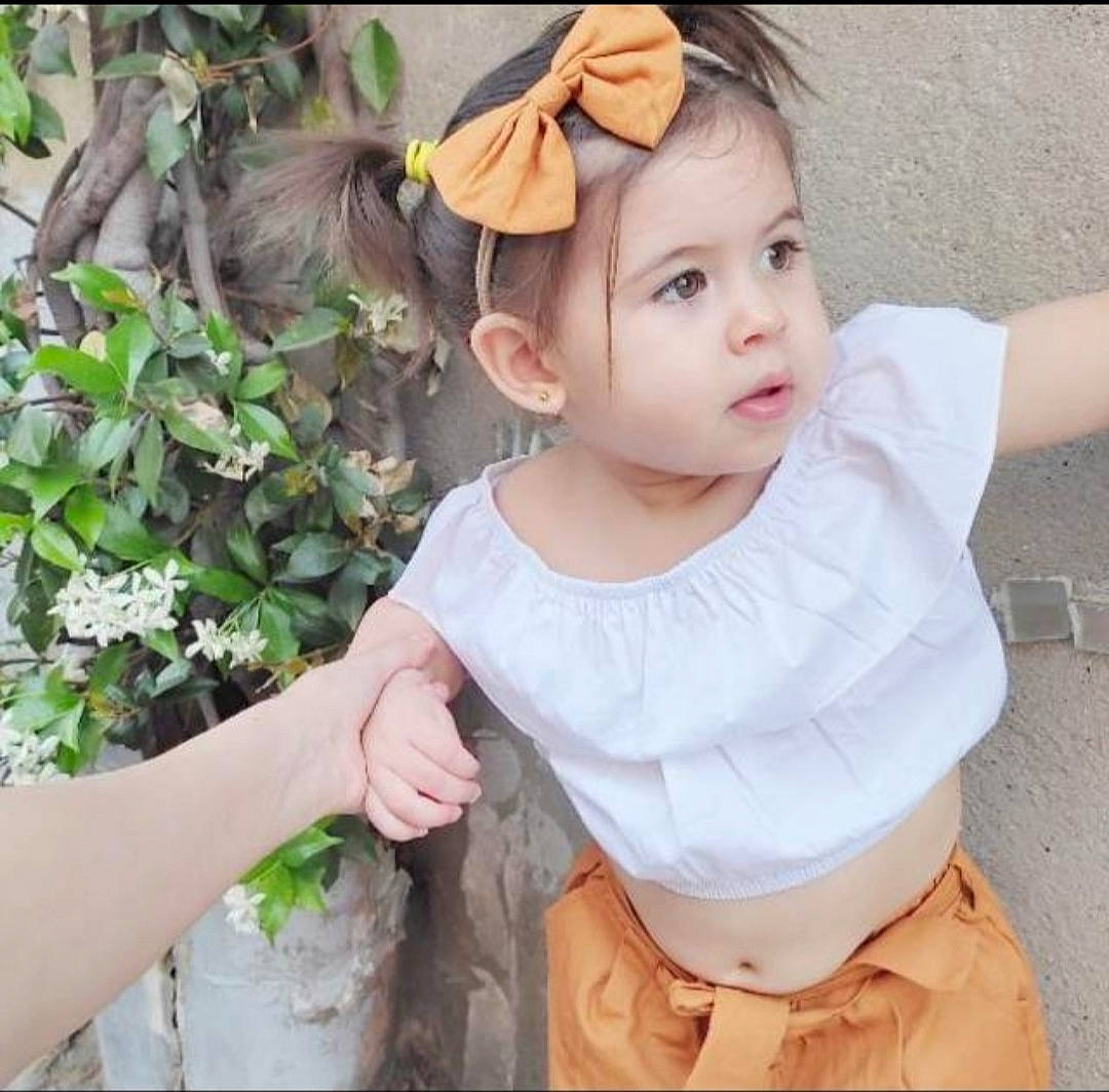 Ayla a rejoint le concours — aidez-le/la à gagner de superbes lots ! baby, baby_toddler_clothing, child, eyelash, fashion_accessory, gesture, grass, hair_accessory, happy, headband, headwear, neck, pattern, peach, person, plant, sitting, skin, sleeve, t_shirt