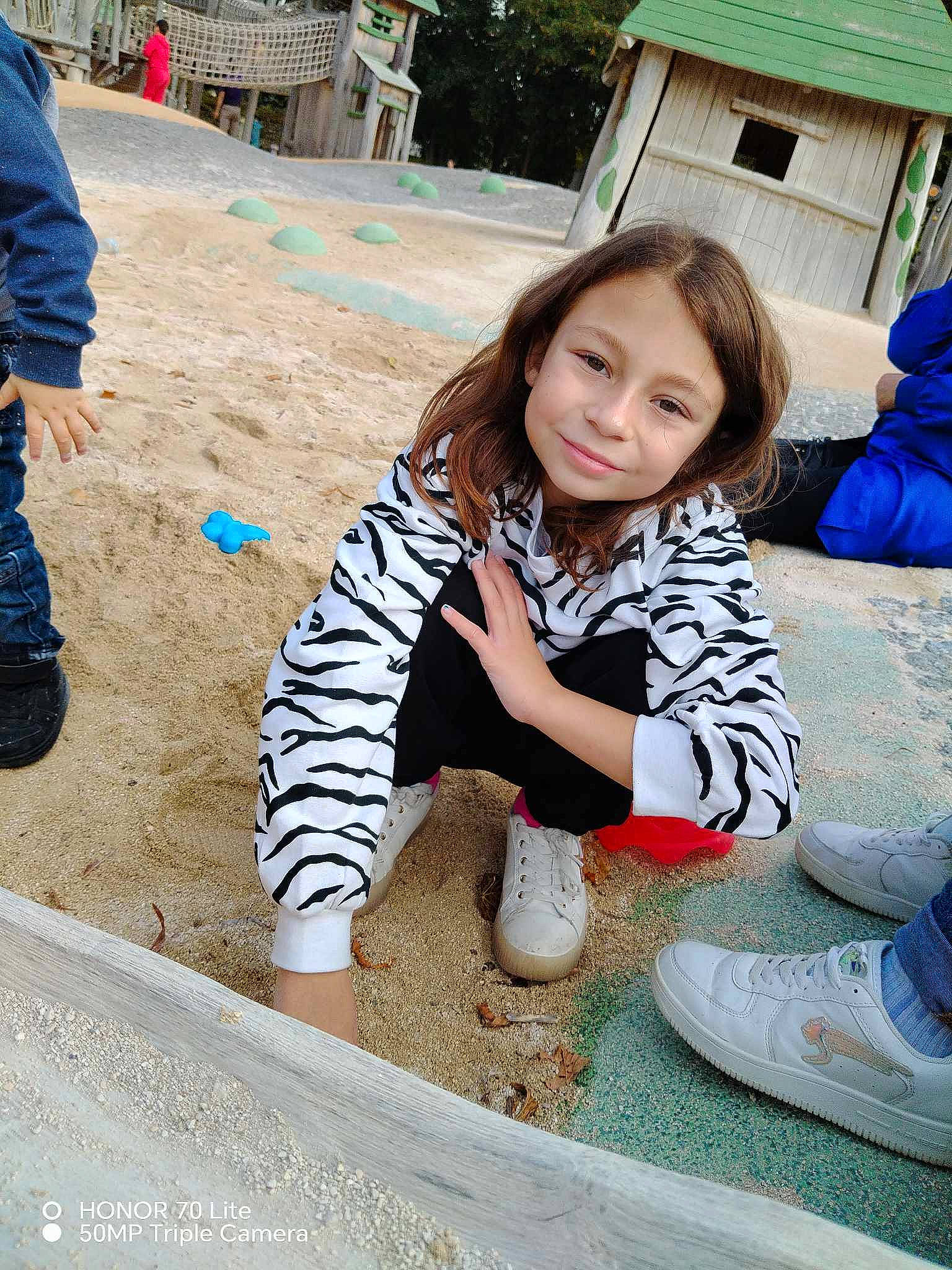 Mya participe au concours pour gagner de l'argent avec cette photo : child, concrete, fun, grass, hairstyle, happy, human_leg, joy, leisure, outerwear, person, plant, recreation, road_surface, shoe, sitting, sneakers, soil, thigh, toddler