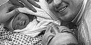 Kody-Blu is registered to the contest to win money with this photo: newborn, baby, man, woman, hospital, surgical_cap, medical_gloves, delivery_room, birth, family, smiling, towel, patient, bed, medical_staff, black_and_white, portrait, closeup, happy, intimate_moment