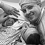 newborn, baby, man, woman, hospital, surgical_cap, medical_gloves, delivery_room, birth, family, smiling, towel, patient, bed, medical_staff, black_and_white, portrait, closeup, happy, intimate_moment