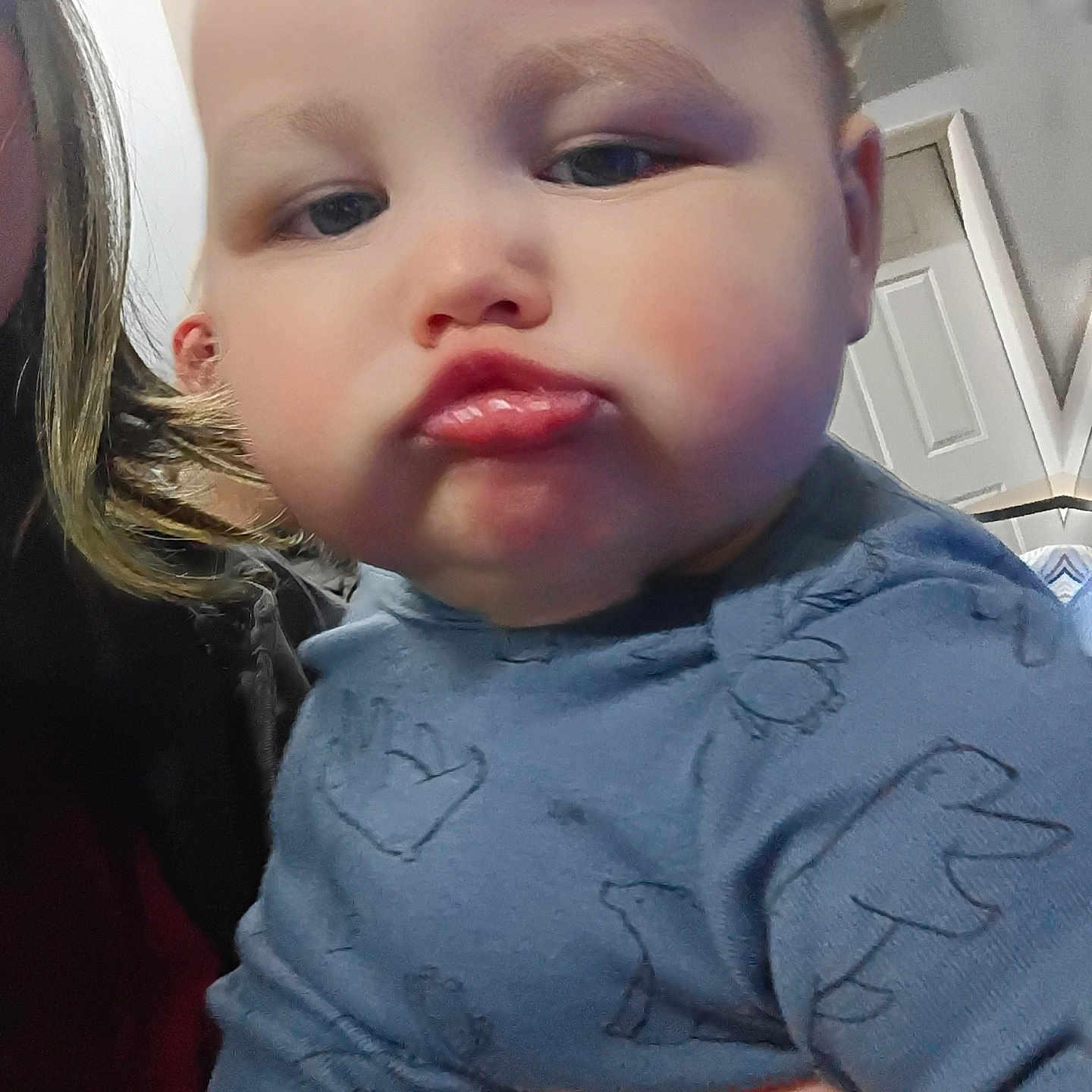 William joined the competition — help win amazing prizes! baby, child, pout, face, expression, blue_clothing, hand, indoor, portrait, cute, chubby_cheeks, person, closeup, infant, young_child, skin, head, eyes, lips, holding