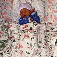 Layla joined the competition — help win amazing prizes! newborn, baby, sleeping, blanket, floral, hat, onesie, bed, bedding, cozy, infant, cute, soft, pink, blue, pattern, peaceful, child, resting, indoors