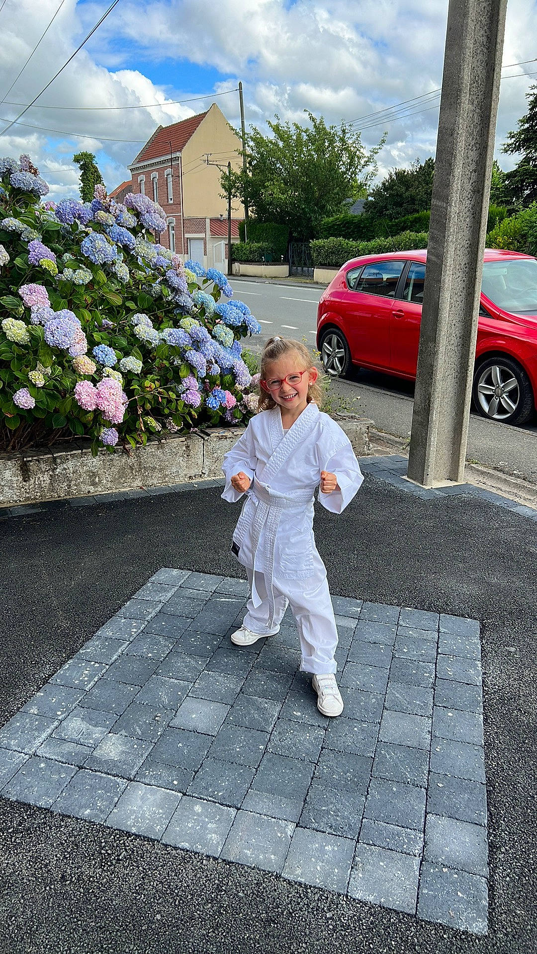 Clémence a rejoint le concours — aidez-le/la à gagner de superbes lots ! asphalt, car, cloud, flooring, flower, grass, house, joy, leisure, motor_vehicle, person, petal, plant, road, road_surface, sidewalk, sky, tire, toddler, tree