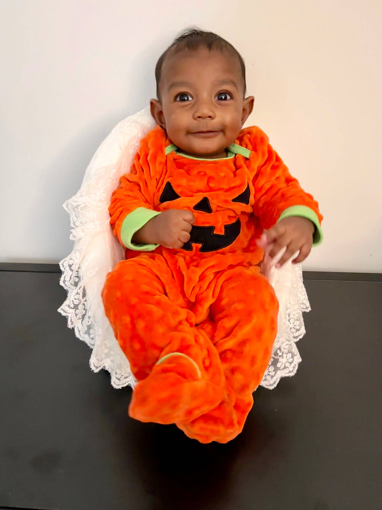 Aiden joined the competition — help win amazing prizes! baby, baby_toddler_clothing, child, dress, eye, face, flooring, happy, human_body, joy, orange, peach, person, personal_protective_equipment, plant, pumpkin, sitting, sleeve, smile, t_shirt