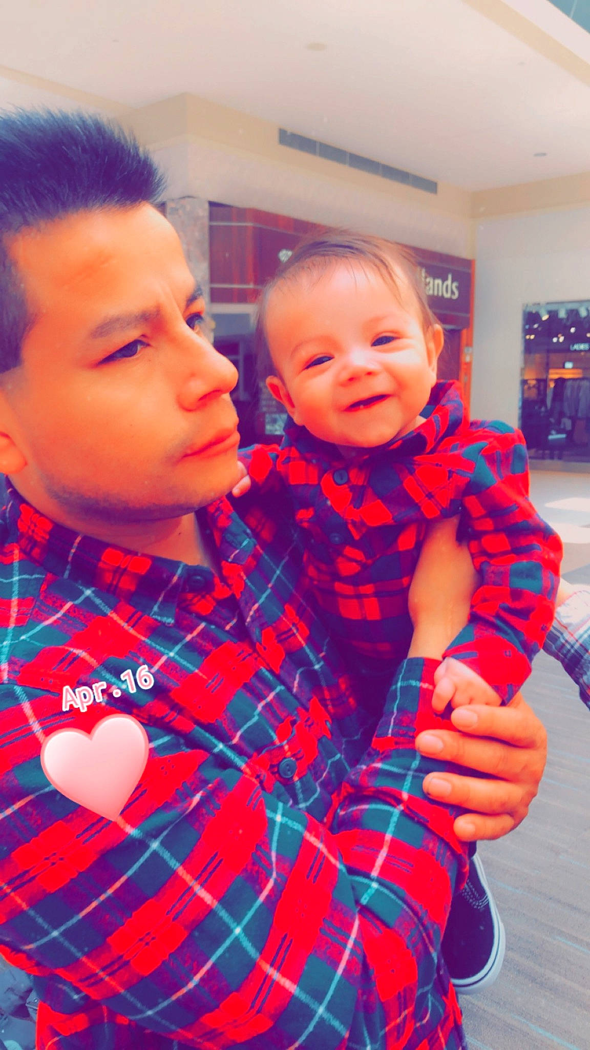 Sebastian is registered to the contest to win money with this photo: baby_toddler_clothing, cheek, child, eye, facial_expression, fun, gesture, hairstyle, happy, head, interaction, people, person, plaid, red, skin, smile, standing, tartan, textile